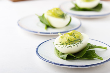 Deviled eggs with avocado and spinach on festive Easter table
