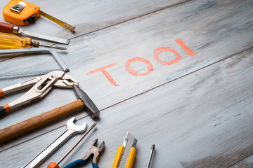 Set of work tool on rustic wooden background with written 