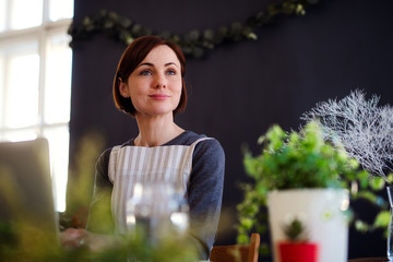 Young creative woman in a flower shop. A startup of florist business.