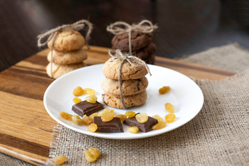 Homemade pastry, raisins and slices of milk chocolate on white plate.