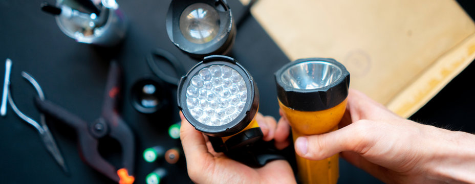 Persons Hands Hold A Flashlight In A Workshop B