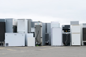 Old fridges freezers refrigerant gas at refuse dump skip recycle stacked pile plant help...