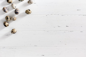 Quail eggs on white wooden minimal background