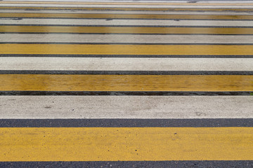 Crosswalk on the street with white and yellow stripes