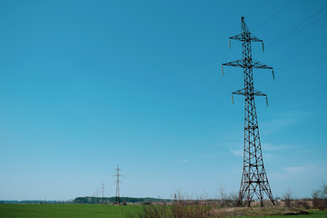 High-voltage tower against the blue sky. Electrical tower with wires.
