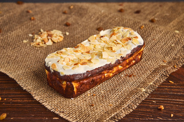 fresh classic vanilla cheesecake decorated by almond flake on wooden background