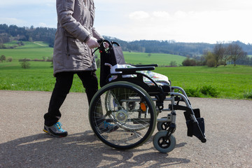 senior lady pushing wheelchair