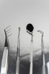 Set of professional dentist tools on gray metal background. Dental hygiene and health concept