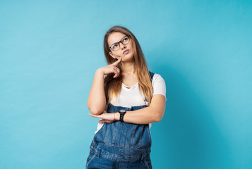 A coquette pregnant woman with glasses making a thoughtful face expression