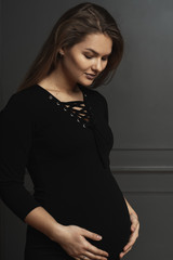 Portrait gorgeous young pregnant woman touching gently with hands her belly, she is waiting a new life