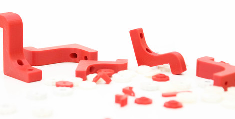 3d printing plastic part red isolated on white background, produced from pla, horizontal view, macro
