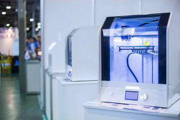 Automatic three dimensional 3D printer machine working at modern technology exhibition. 3D printing, additive technologies, 4.0 industrial revolution and futuristic concept