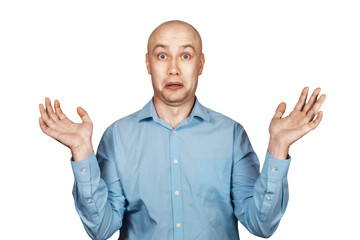 Portrait bald unsure man doesn't understand anything and spreads his hands. guy in a blue shirt on white isolated background in perplexity