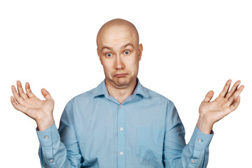 Portrait bald unsure man doesn't understand anything and spreads his hands. guy in a blue shirt on white isolated background in perplexity