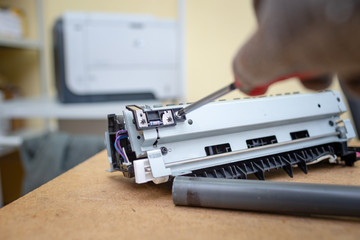 Specialist repairs laser printer. Worn and torn thermal film. Faulty thermal node