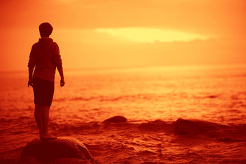 landscape sunset on the sea, man on the lake shore at sunset, beautiful place  nature, water and seashore, concept of waiting for loneliness