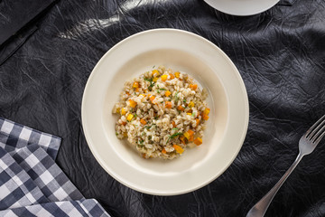 Tasty Pearl barley porridge with carrot on black table