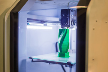 Automatic three dimensional 3D printer machine printing plastic model of building at modern...