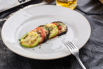 Grilled eggplant, zucchini, peppers sliced on black table