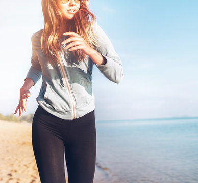 Fashionable young longhaired woman have morning jogging on the calm sea coast