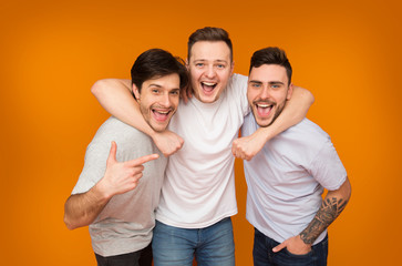 Best friends. Men posing over orange background