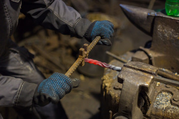 Professional blacksmith working with metal at forge, workshop. Handmade, craftsmanship and...