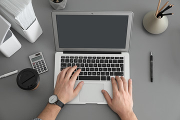 Man using laptop at table, top view. Space for design