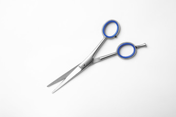 New scissors on white background, top view. Professional hairdresser tool