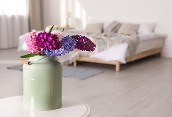 Beautiful hyacinths in metal can on table indoors, space for text. Spring flowers
