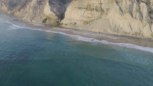 A beautiful reverse pan of California coastline cliffs with view of beach homes