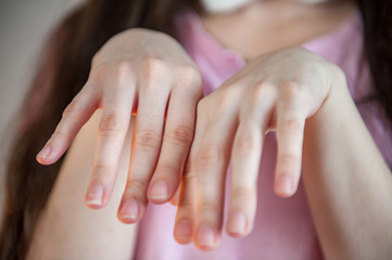 young girl with long hair in pink carnival rabbit costume. On hair are fixed white-pink ears of Easter Bunny. White and pink stockings, bow tie, big glasses for sight. Easter eve