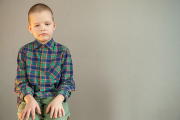 Funny boy from a shelter for visually impaired children shows products made of wicker made in class work.