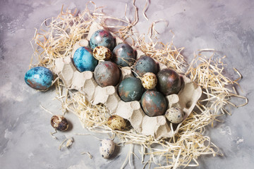 Fototapeta na wymiar Quail and chicken painted eggs on concrete background. Easter