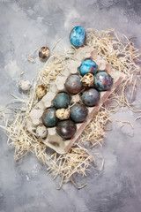 Fototapeta na wymiar Quail and chicken painted eggs on concrete background. Easter decorations.