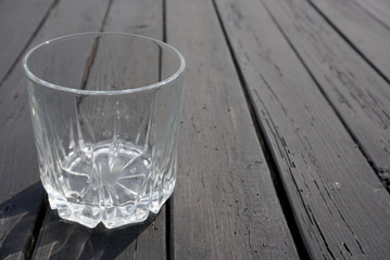 Empty glass on the dark wooden table 