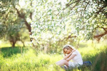 Naklejka na ściany i meble girl sniffing flowers / fresh spring flowers of apple, portrait of a girl in a beautiful spring garden