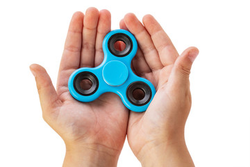 Fototapeta premium Male hand holding baby, holding a popular toy, isolated on white background. A boy is playing with a blue spinner.