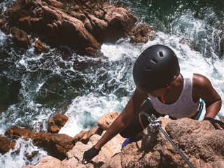 Girl doing via ferrata on the coast of catalonia. (Via ferrata Cala de Molí, Sant Feliu de Guixols)