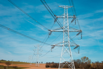 Electrical substation utility pole, state and high voltage power line silhouette with blue cloudy...