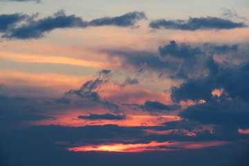 Obraz premium Beautiful fiery orange sunset background with dark clouds