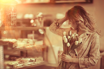 girl with a bouquet of flowers in a cafe / beautiful showcase, diet, happiness, mood