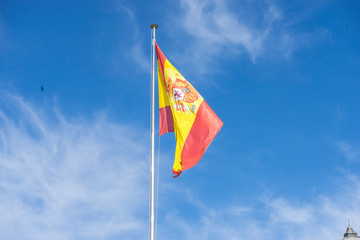 spain flag on a mast in the wind on blue sky background