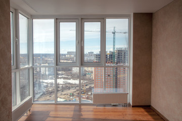 Empty room interior with floor to ceiling windows with city view