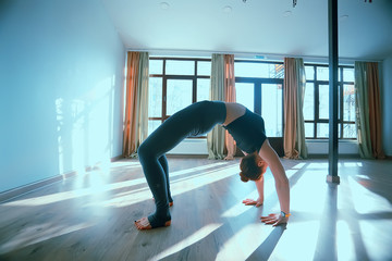 Fototapeta na wymiar yoga balance girl / Yoga coach shows balance, yoga postures. Beautiful sporty graceful girl in the gym