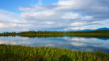 Beautiful summer landscape from the lake, fields, mountains and sky. Baikal, Russia.