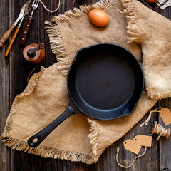 Overhead shot of cast-iron pan standing on sackcloth on wooden rustic table