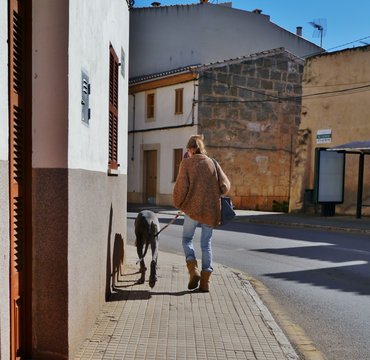 Frau mit Riesenhund im Dorf