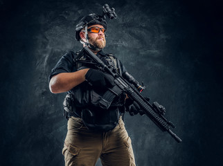 Special forces soldier wearing body armor and helmet with night vision holding an assault rifle....