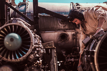 Worker is focused on jet's engine.