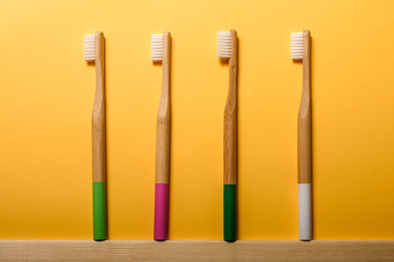 full colours bamboo toothbrushes on yellow background. Place for text. Ecoproduct.   eco-friendly